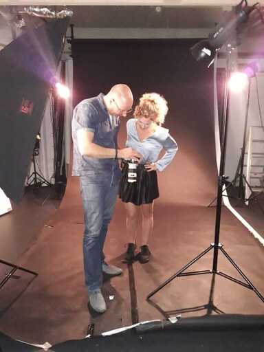 Backstage tijdens een fotoshoot in de studio samen met het model